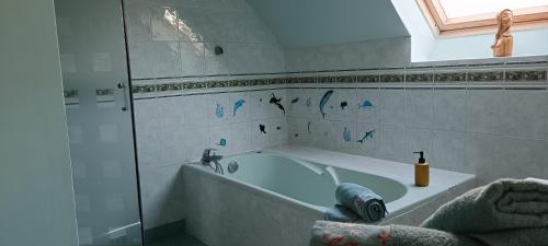 biała łazienka z wanną i oknem w obiekcie Escale Côte et Mer w mieście Clohars-Fouesnant