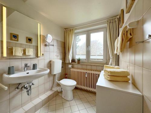 a bathroom with a toilet and a sink at Gemütliches Appartement in Tinnum in Tinnum