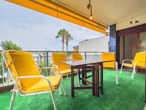 een patio met gele stoelen en een tafel op een balkon bij Apartamento Turístico Eme in Cambrils