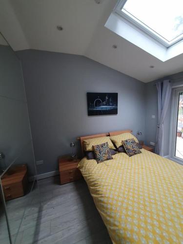 1 dormitorio con 1 cama con edredón amarillo y ventana en Lovely double room with en-suite bathroom en The Hyde
