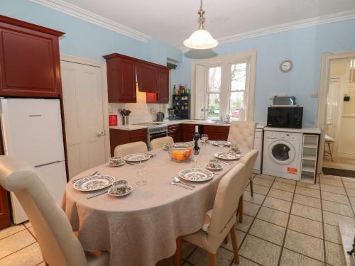 a kitchen with a table with chairs and a table cloth at Leazes Cottage in Durham