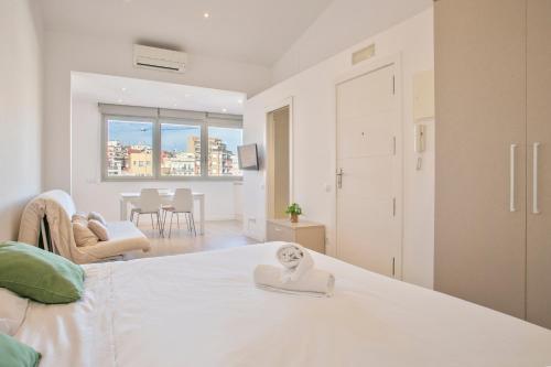 a bedroom with a bed with a towel on it at BcnStop Sant Pau Suites in Barcelona