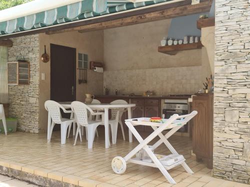 une cuisine avec une table et des chaises sur une terrasse dans l'établissement VILLA - piscine - Swimming Pool, à Saint-Julien