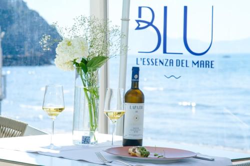 a table with a bottle of wine and a plate of food at Villa Aragonese Rooms in Monte di Procida