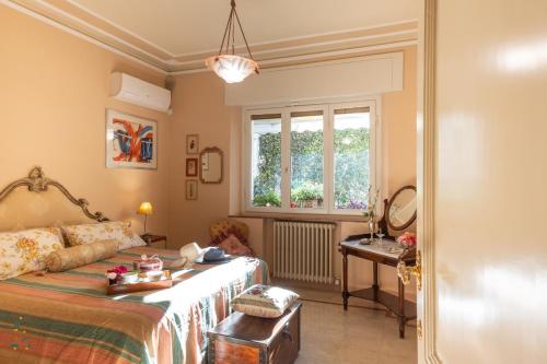 een slaapkamer met een bed, een tafel en een raam bij La Romantica Veranda Free Parking and Garden in Lucca
