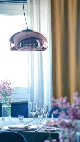 a pendant light hanging over a table with wine glasses at Villa Aragonese Rooms in Monte di Procida