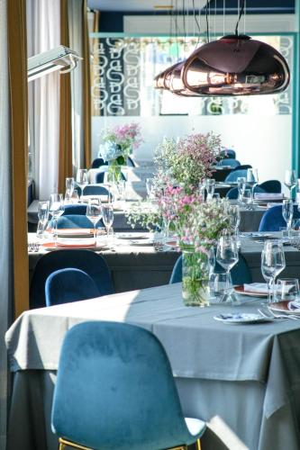 a dining room with tables with blue chairs and flowers at Villa Aragonese Rooms in Monte di Procida