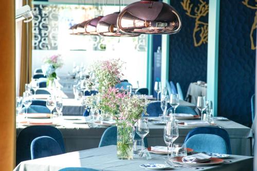 a dining room with long tables with vases of flowers at Villa Aragonese Rooms in Monte di Procida
