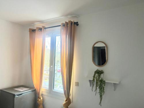 a window with curtains and a mirror in a room at Studio -SweetHome - Paris-Disney - 3 Min Gare in Bussy-Saint-Georges