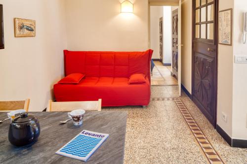 a red couch in a living room with a table at PORTOVECCHIO Plus in Levanto