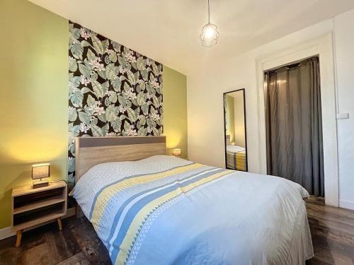- une chambre avec un lit orné d'un mur fleuri dans l'établissement Appartement à 30 m de la plage - balcon - proche Centre - WIFI -Le Cérès 3, à Berck-sur-Mer