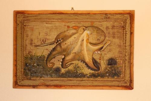 a painting of an octopus in a wooden frame at PORTOVECCHIO Plus in Levanto