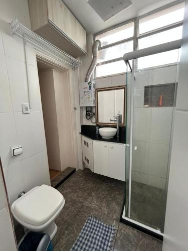 uma casa de banho com um chuveiro, um WC e um lavatório. em Apartamento em Botafogo no Rio de Janeiro