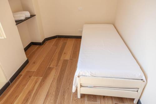 a bed in a small room with a wooden floor at PORTOVECCHIO Plus in Levanto