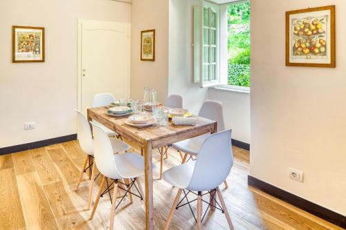 a dining room with a wooden table and white chairs at PORTOVECCHIO Plus in Levanto