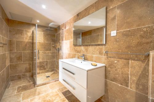 une salle de bain avec un lavabo et une douche dans l'établissement Villa Bagatelle, à Grimaud