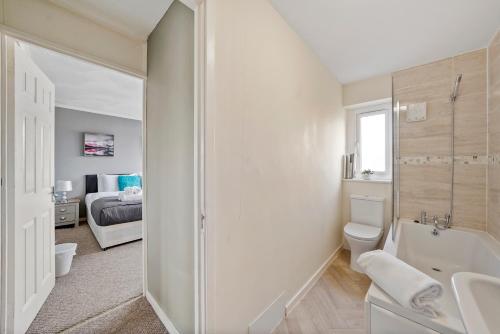 a bathroom with a sink and a toilet and a bedroom at 4 Bed House with Parking and Garden - Sleeps 8 in Kent