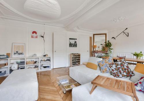 un salon avec un canapé blanc et une table dans l'établissement Gorgeous, bright & large 1 BR near Montmartre, à Paris