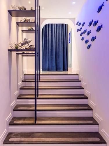 a set of stairs in a home with blue curtains at Villa Aragonese Rooms in Monte di Procida