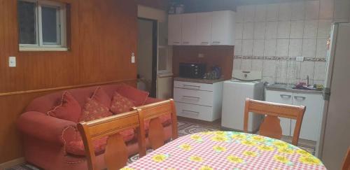 sala de estar con sofá y cocina en Casa Dichato, en Dichato