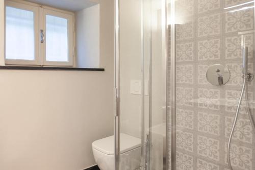 a bathroom with a toilet and a glass shower at PORTOVECCHIO Plus in Levanto