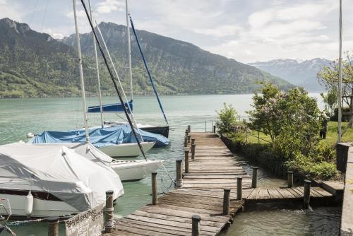 two boats docked at a dock on a lake at Boutique Hotel Riviera in Spiez