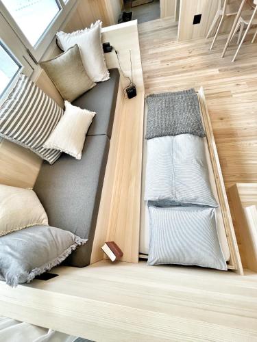 a living room with a couch and pillows at Nanisgarten - Grannys flat in Obergesteln