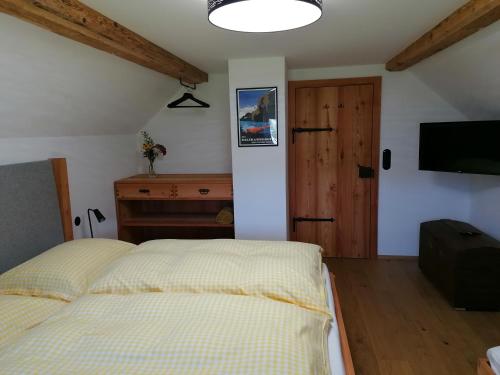 a bedroom with a bed and a desk and a television at Ferienhaus Asterbach in Gosau