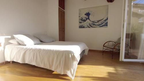 - une chambre avec un lit et un tableau d'une vague dans l'établissement Lovely house teracce and parking in historic center, à Aix-en-Provence
