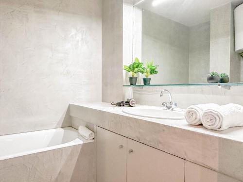 une salle de bain blanche avec un lavabo et une baignoire dans l'établissement Lake view - VUE INCROYABLE sur le lac, à Annecy