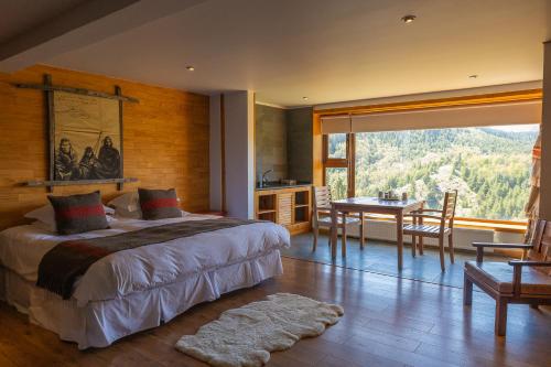 a bedroom with a bed and a dining room with a table at HOTEL NOMADES PATAGONIA in Coihaique