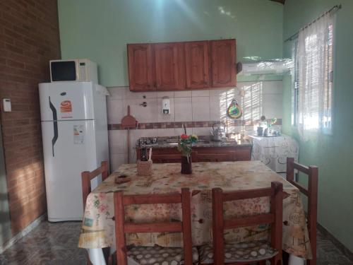 a kitchen with a table and a white refrigerator at cabañas elita in San Rafael