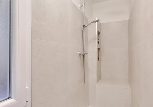 une douche avec une porte vitrée dans une salle de bain dans l'établissement Gorgeous, bright & large 1 BR near Montmartre, à Paris