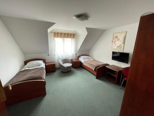 ブジェスコにあるHotel Augustのベッド2台とテレビが備わるホテルルームです。