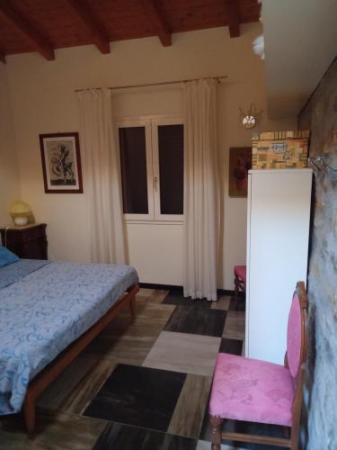 a bedroom with a bed and a chair and a door at Ca' d Licio - Attico in Polinago