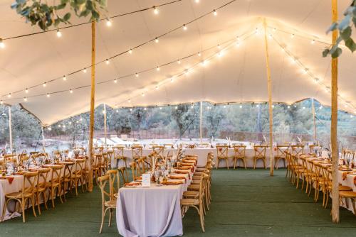 a marquee set up for a wedding with tables and chairs at Hotel-Masia Can Farrés in El Bruc