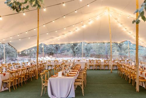 una carpa preparada para una boda con mesas y sillas en Hotel-Masia Can Farrés, en El Bruc