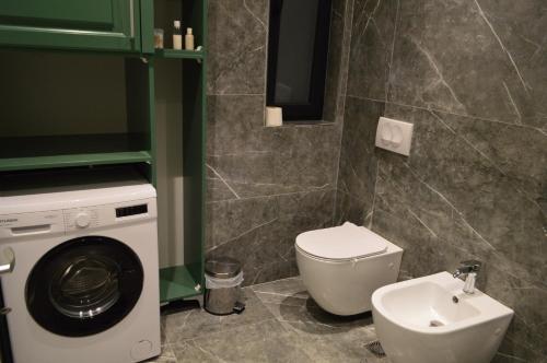 a bathroom with a washing machine and a toilet at Tirana Getaway Apartments - Central in Tirana