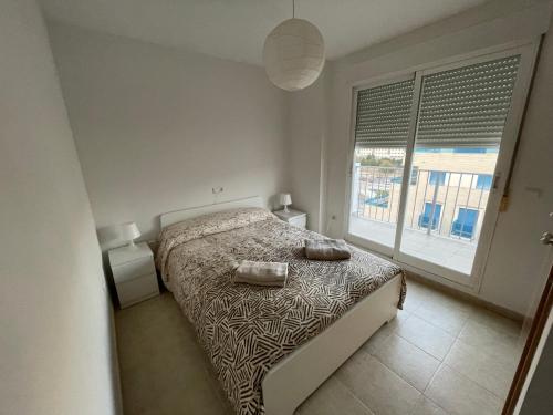 a bedroom with a bed and a large window at Apartamento ático en Denia in Denia