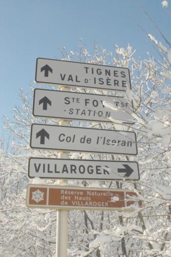 a pile of street signs on a pole at Hotel Le Monal in Sainte-Foy-Tarentaise