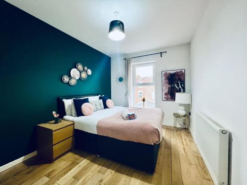 - une chambre avec un lit et un mur bleu dans l'établissement Lovely 3 Dbl Bed (sleeps upto 6) close to centre., à Manchester