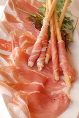 a plate of meat with carrots and greens on it at Hotel Le Monal in Sainte-Foy-Tarentaise
