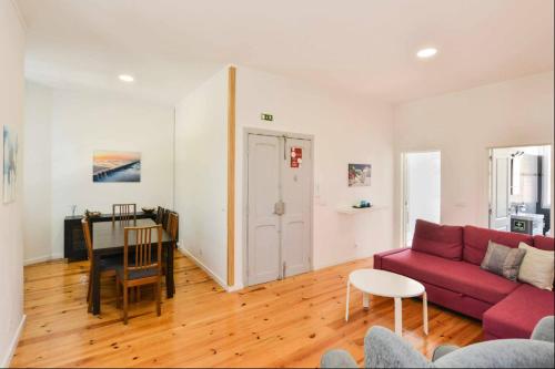 a living room with a red couch and a table at Lightoasis Oeiras 2 in Oeiras