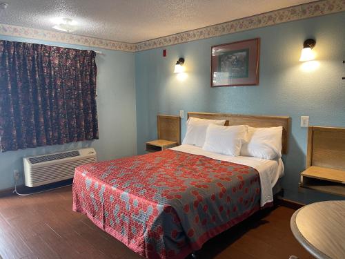 a hotel room with a bed and a window at Chester Inn Motel in Stanton