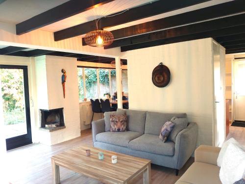 een woonkamer met een bank en een salontafel bij Vrijstaande vakantiebungalow met optimale privacy!! in Rekem