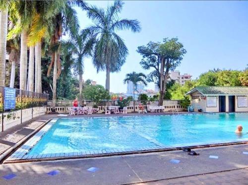 a large swimming pool with palm trees in a resort at Nirun Grand Ville C4 in Pattaya Central