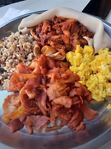 a plate of food with bacon eggs and rice at Tryst Boutique Hotel in Addis Ababa