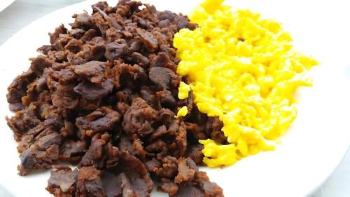 a plate of food with meat and yellow rice at Tryst Boutique Hotel in Addis Ababa