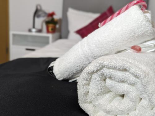 Una toalla blanca sobre una cama en City Hotel - Einzelzimmer en Rastatt