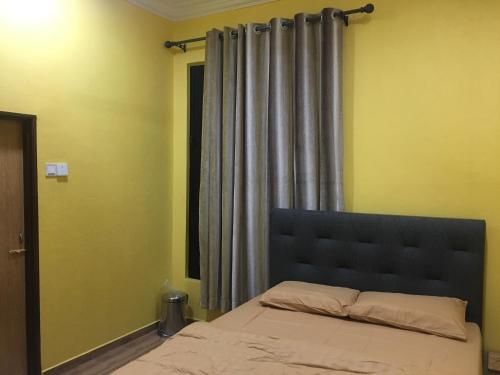 a bedroom with a bed and a window with curtains at The Pines Small Studio in Kota Bharu